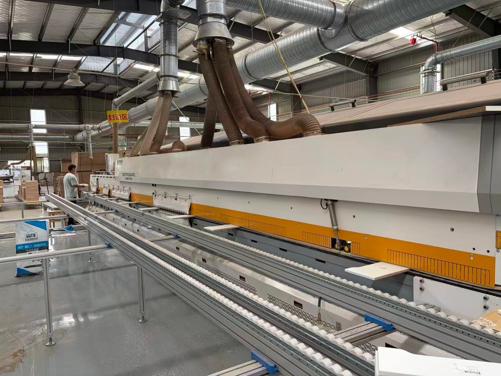 Enclosed woodworking equipment with dust extraction in the company-supplied production hall